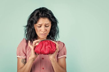 Mutsuz, esmer, güzel bir kadın. Kırmızı cüzdan tutuyor, tasarruf ediyor..