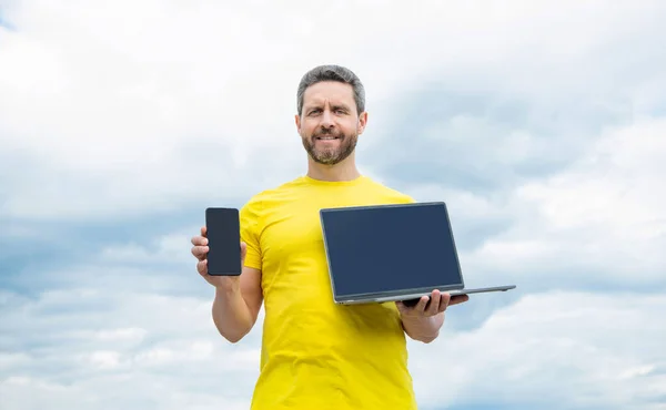 Man Presenting Smartphone Laptop Display Sky Background — Foto de Stock
