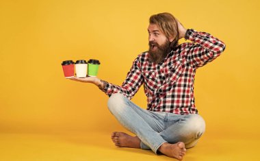 Zor seçim. İlham konsepti. Hipster adam kahve içer. Beyaz bardak tutan yakışıklı sakallı adam. Bardakla içecek. Çay ya da kahve içmek. Günaydın. Evde sabah titreşimleri.