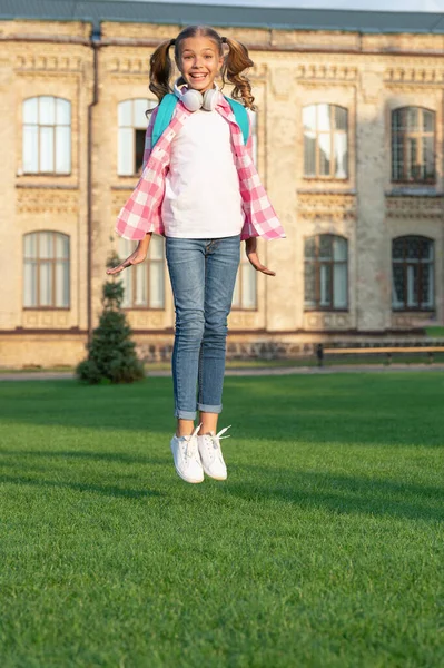 快乐精力充沛的少女在户外的校园里跳跃 知识日 — 图库照片