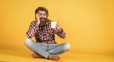 İlham için biraz kahveye ihtiyacım var. Güne mükemmel bir başlangıç. Mutlu sakallı adam sabah kahvesini içiyor. Adam fincandan sıcak çay içiyor. Sana da günaydın. Enerjik, sıcak bir içecek. reklam için boşluk kopyala.