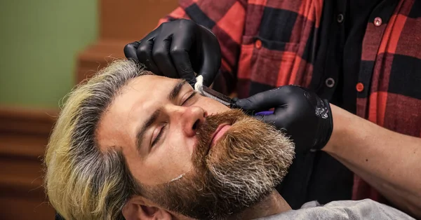 brutal bearded man at hairdresser salon with master, grooming.