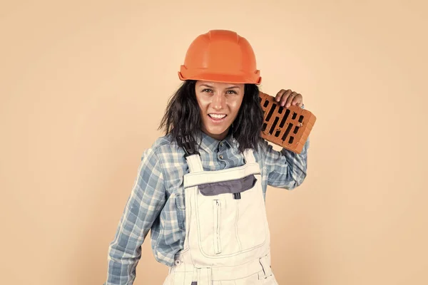 Building tomorrow. girl in workshop uniform. repairing tools used in engineering. architect working with brick. female foreman on construction site. builder assistant wear protective helmet.