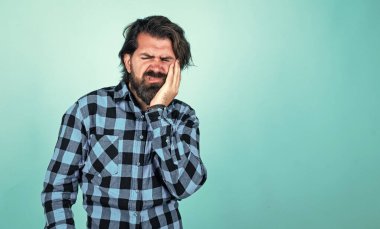 Sakallı ve bıyıklı yakışıklı hippi diş ağrısı ve stomatolojiden muzdarip..