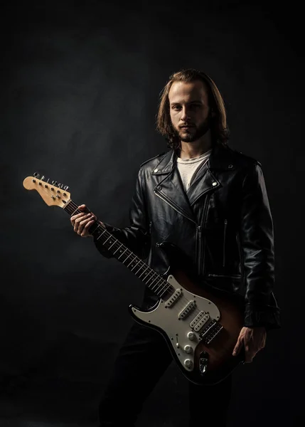 hobby. rock music style. musician guitar player. masterfully playing rock music. stylish crazy man. string musical instrument. bearded rocker in leather jacket. man long hair play electric guitar.