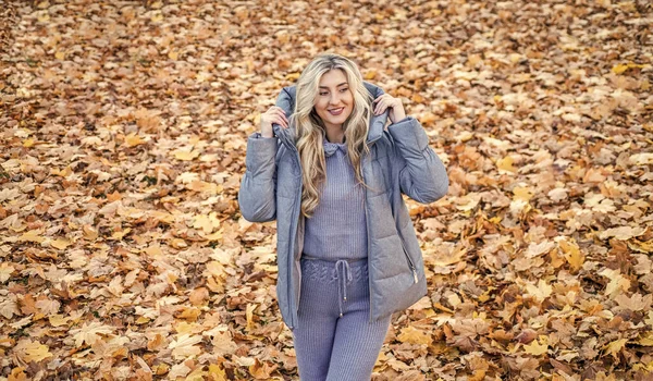 快乐的女人笑着穿针织衫和温暖的户外衣服秋天风格的外套黄色落叶 — 图库照片
