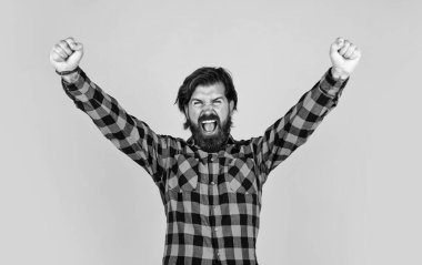 Mutlu kazanan yakışıklı adam sarı arka planda dururken el kol hareketi yapıyor ve ağzını açık tutuyor, mutluluk..