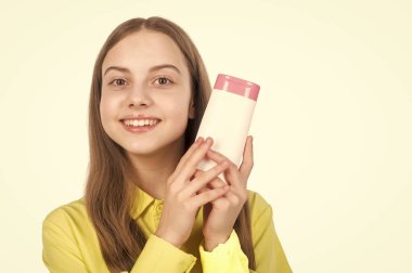 Mutlu çocuk sunar şampuan veya saç kremi şişesi beyaz fotokopi alanında izole edilmiş, ürün sunar.