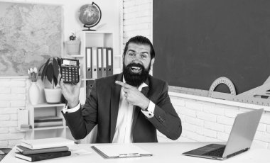 Mutlu erkek, sakallı, matematik ve matematik dersinde hesap makinesiyle hesap yapıyor..