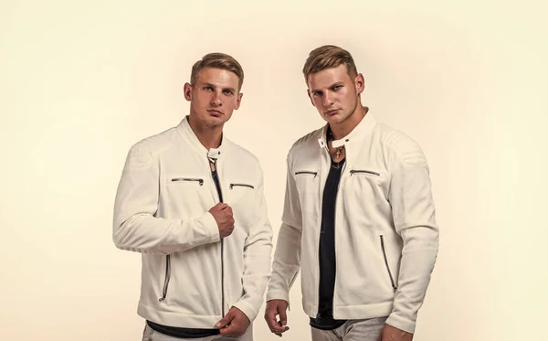 twin brothers men in white casual clothes look alike, identically.
