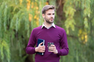 Genç yakışıklı adam dışarıda kahve molası veriyor..