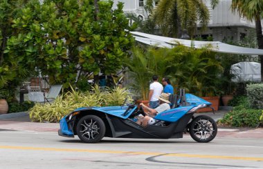 Miami Beach, Florida USA - 19 Mart 2021: Mavi polaris sapanı yolda, yan görüş. Üç tekerlekli motosiklet..
