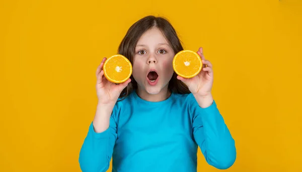 Amazed Teen Girl Holding Orange Fruit Yellow Background — Φωτογραφία Αρχείου