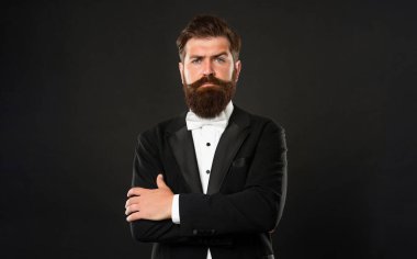 elegant butler in tuxedo on black background, fashionist.
