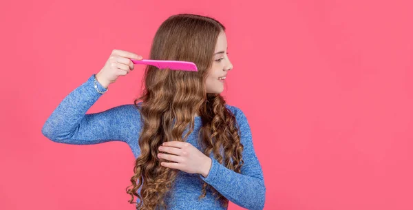 Nastolatka Dziewczyna Czesanie Kręcone Włosy Szczotką Włosów Różowym Tle Przestrzeń — Zdjęcie stockowe