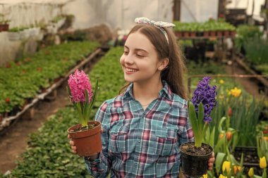 Seçenek. Bahar ve yaz. Saksı bitkileri ekiyorum. Çocuk bahçıvanı. Bahçedeki çiçekler. Günlük ev işleri. Çiçek bakımı. Bahçecilik. Çocuklar için bahçe işleri. Seradaki mutlu genç kız çiçekçi..