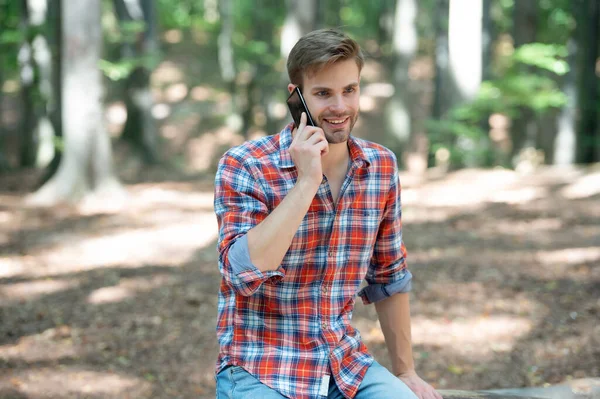 young handsome man in checkered shirt talk on phone outdoor.