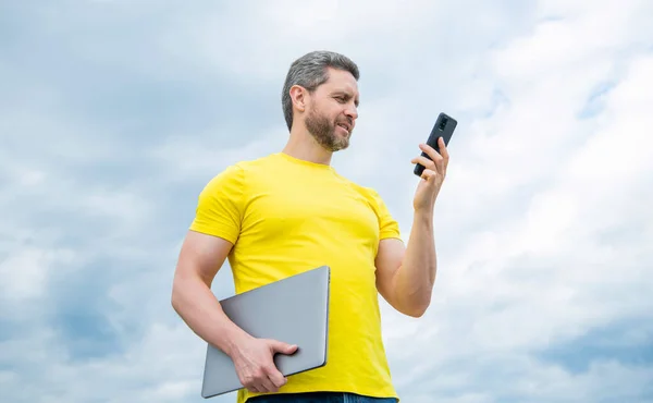 Hombre Con Ordenador Portátil Usando Teléfono Fondo Del Cielo — Foto de Stock