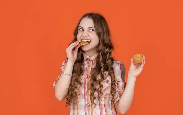Hungry Teen Girl Oatmeal Cookies Orange Background — Φωτογραφία Αρχείου