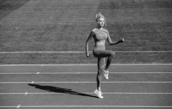フィットネススポーツウェアの女性ジャンプ 屋外のアリーナで暖まりなさい トレーニングとトレーニングです 運動女子コーチ 女性スポーツトレーナー 健康的なスポーティーなライフスタイル 健康とエネルギーです ダイエット — ストック写真