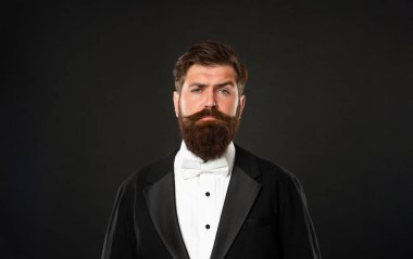 bearded businessman in tuxedo on black background, menswear.