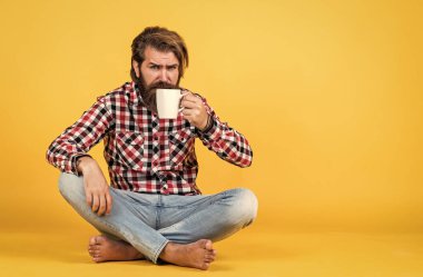 Bardakla içecek. Çay ya da kahve içmek. Günaydın. Evde sabah havası var. İlham konsepti. Hipster adam kahve içer. Beyaz bardak tutan yakışıklı sakallı adam. Boşluğu kopyala.