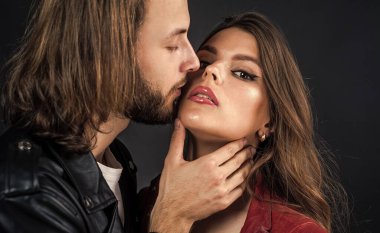 Benimle ol. Sakallı, uzun saçlı adam, kadını okşar. Aşk ve romantizm. Romantik ilişki. Sevgili portresi. Öpücük. Birbirine aşık çiftler. Deri ceketli şık bir çift..