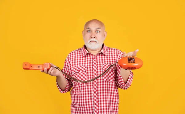 Stupito Uomo Anziano Con Telefono Retrò Sfondo Giallo — Foto Stock