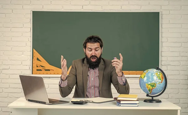 mature bearded man teacher in costume sit in school classroom with geography globe map, destination.
