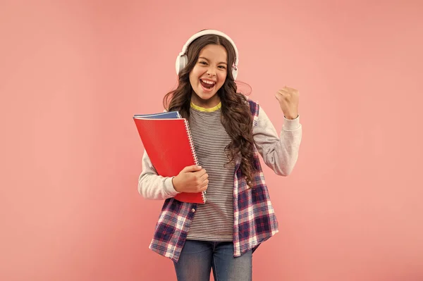 Επιτυχημένο Παιδί Ακούστε Μουσική Στα Ακουστικά Κρατήστε Βιβλίο Εργασίας Ροζ — Φωτογραφία Αρχείου