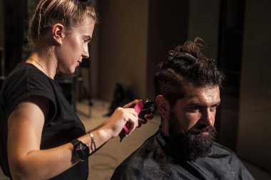 Adam tıraş oluyor. Kuaförde sakallı, olgun bir hippi. Bıyıklı vahşi hippi yeni saç stili yapıyor. Berber dükkanı. Erkek saç stili. Tıraş bıçağıyla mükemmel saç kesimi. Berber ustası saç kesti..