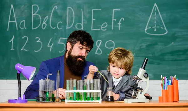 laboratory research and development. father and son child at school. bearded man teacher with boy. lab test tubes and flasks with colored liquids Chemistry experiment. Chemistry come as you are.