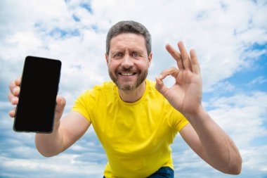 Mutlu adam akıllı telefon ekranına kopyalama alanı sunuyor. Tamam.