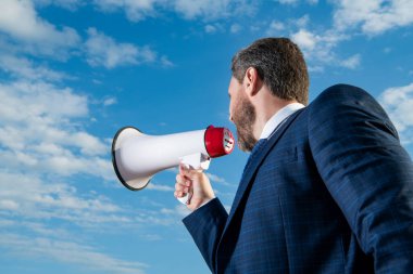 İş adamı arka planda hoparlörle yüksek sesle bağırıyor.