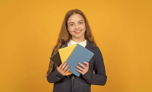 Gülümseyen Çocuk Sarı Arkaplan Üzerine Okul Kitabı Ödevi — Stok fotoğraf