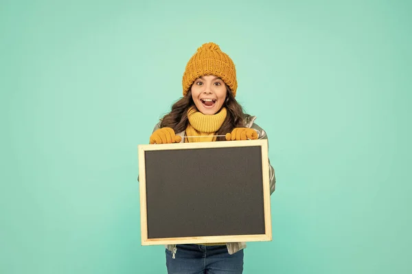 冬服の十代の女の子は青の背景にコピースペースと学校の黒板を保持します — ストック写真