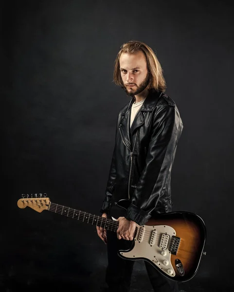 bearded rock musician playing electric guitar in leather jacket, musician.