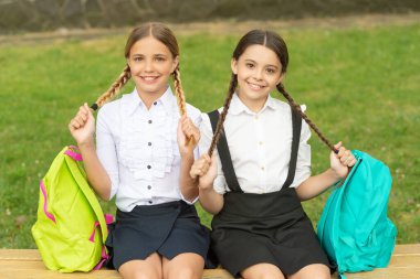 back to school. two smiling teenager children after school outdoor. friendship of school girls.