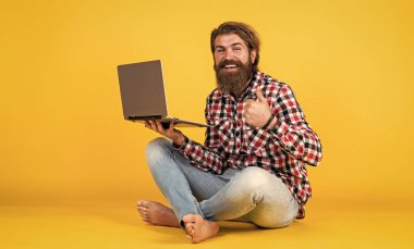 İnternete akın edin. Mutlu adam piyangoyu kazandı. Mesafe öğrenme. Başarıyı hisset. Coronavirus karantinasındayken evden çalışacağım. Dizüstü bilgisayarında çalışan hipster bir adamın portresi. Kendini izolasyon.