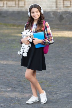 Happy teenage girl back to school holding dog toy, music education. back to school. pupil at school time.