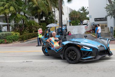 Miami Beach, Florida USA - 19 Mart 2021: Şoförlü mavi polaris sapanı, köşe manzaralı. Üç tekerlekli motosiklet..