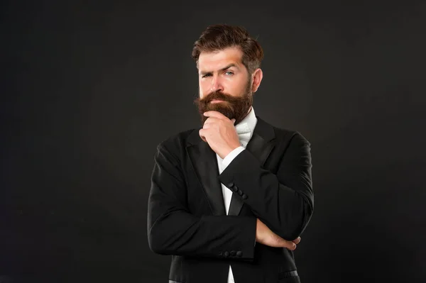 bearded man in tuxedo on black background, tux.