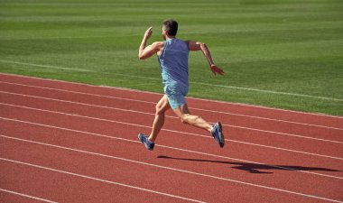 Güneşli bir günde koşan atletik adam, enerjik..