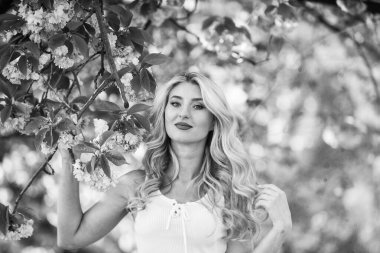 Çiçeklerin kadınları neden her zaman mutlu ettiğini. Mutlu bahar günleri. Kız bahçede sakura çiçeğinin tadını çıkarıyor. Bahar çiçeği açan ağaç. Kiraz ağacı. Çiçek aroması. Uyum ve kadın enerjisi. Bahar sembolü.