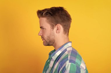 Yakışıklı ve tıraşsız. Profildeki genç adam. Beyaz adamın profil portresi. Erkek yüzü yana doğru görünüyor..