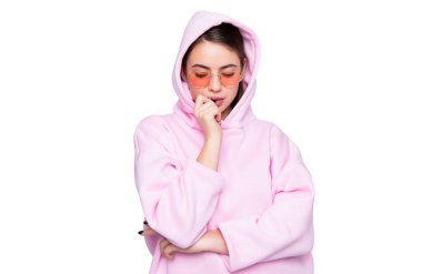 Ciddi düşünceli bir kız, sıradan moda pembe kapüşonlu çivileri yiyor ve beyaz gözlüklü..