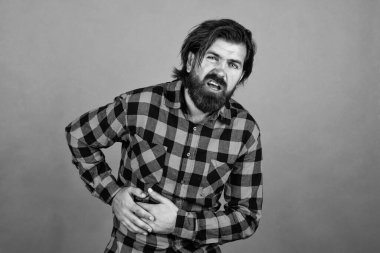 Kareli gömlekli vahşi adamın uzun sakalı vardır. Ağrı ve ilaç hisseder..