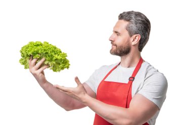 Önlüklü bir adam marul sunuyor..