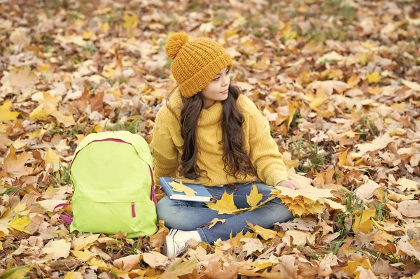 back to school. natural beauty. fall season fashion. teen girl in hat hold autumn leaf. child relax with yellow maple leaf and backpack outdoor. autumn nature.