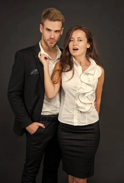 formal man and woman in business look on black background, cooperation.